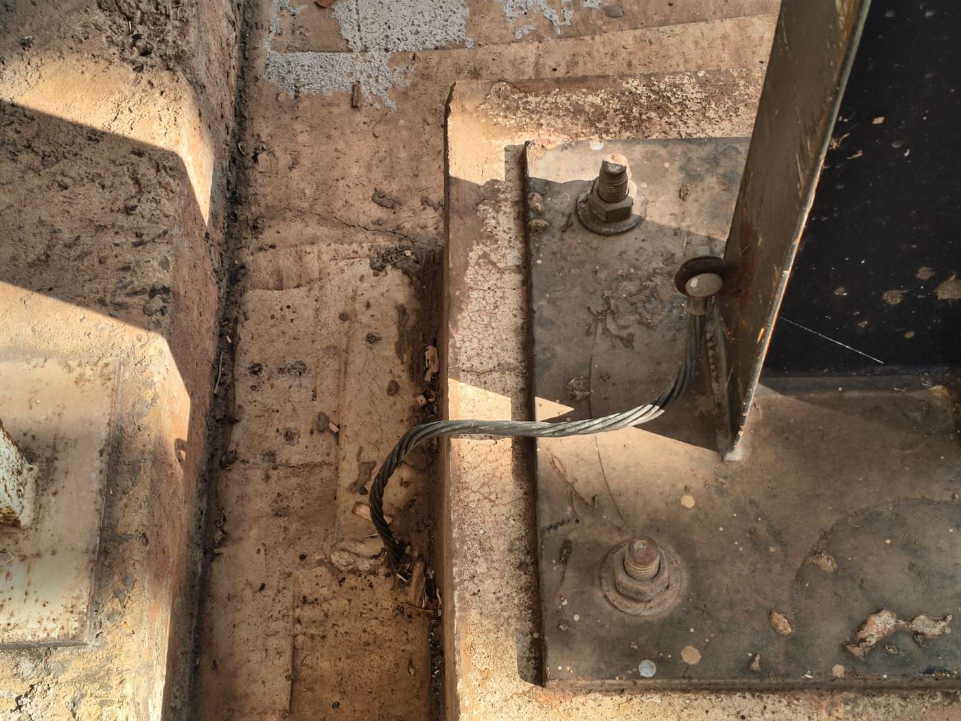 Cabo de cobre nu conectado por parafuso à chapa de base de uma estrutura metálica